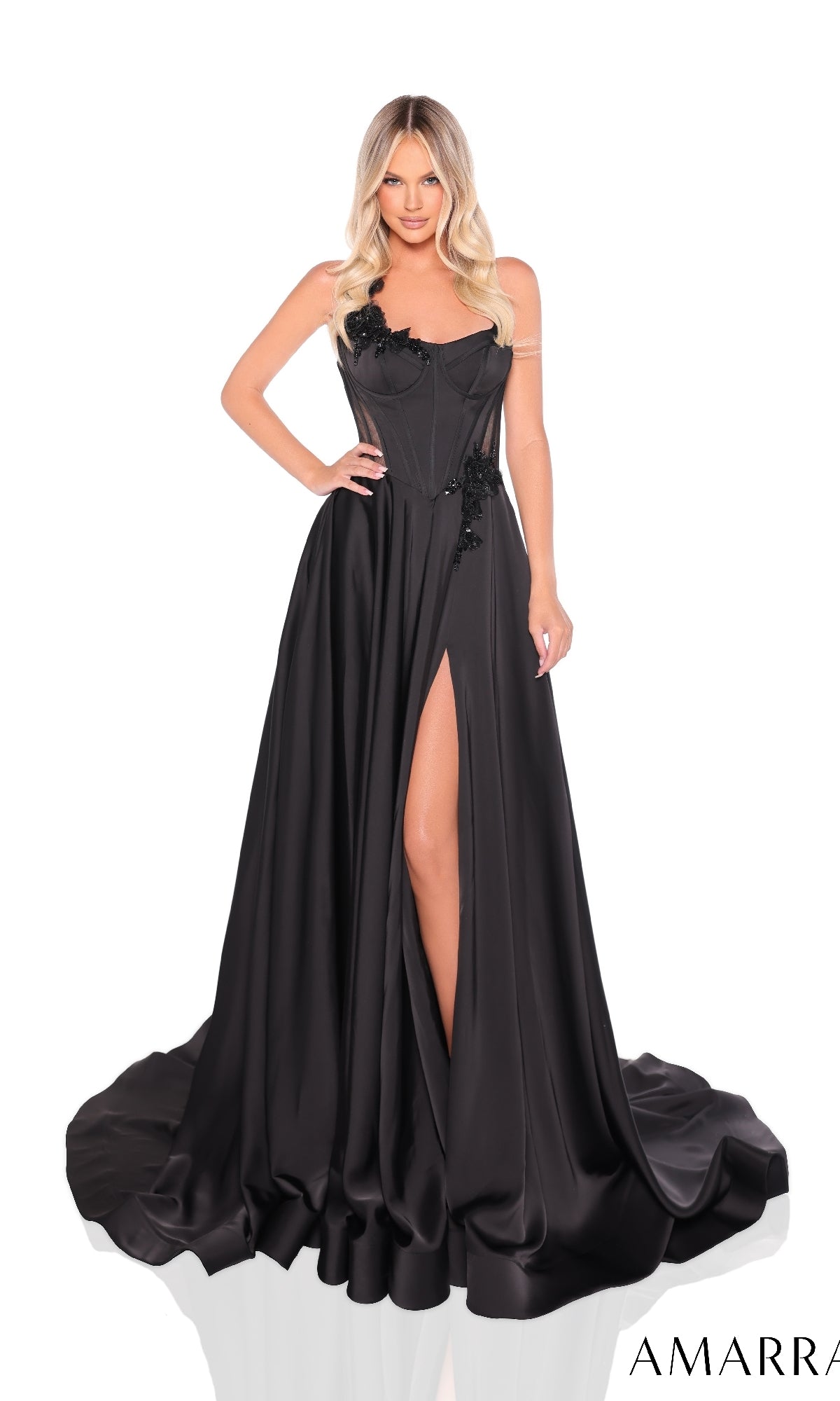 A woman in the Amarra 88214 long prom dress?strapless, floor-length black satin with a corset bodice, high leg slit, and floral appliqu‚?stands against a white background.
